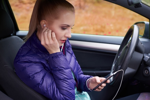 Woman settings of the phone in the car