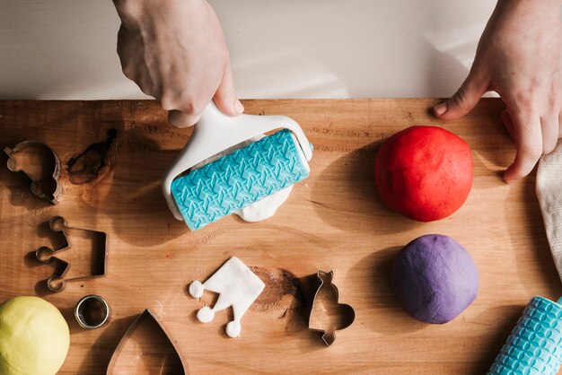 Woman shaping colorful plasticine on wood board