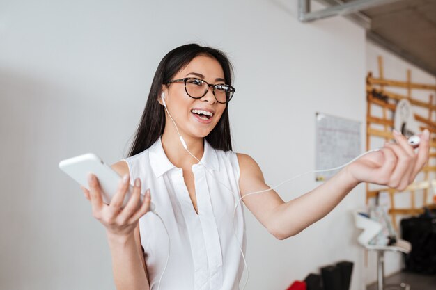 Woman sharing one earphone with somebody for listening to music