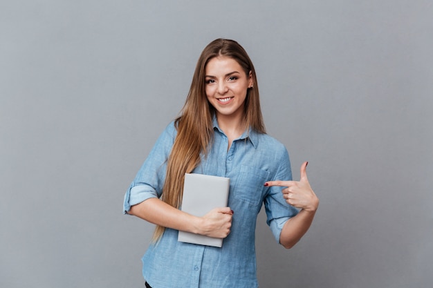Woman in shirt holding book in hand