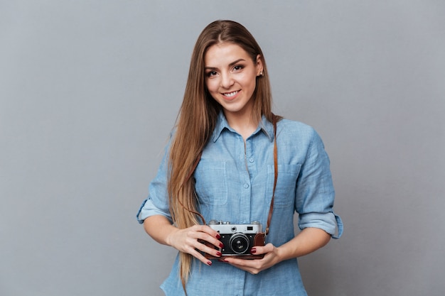 Woman in shirt holding retro camera