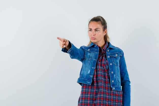 Free photo woman in shirt, jacket pointing away and looking focused , front view.