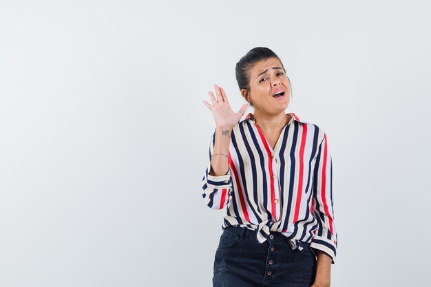 Foto gratuita donna in camicia, gonna agitando la mano per salutare