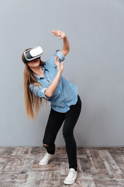 Женщина в рубашке с помощью устройства виртуальной реальности