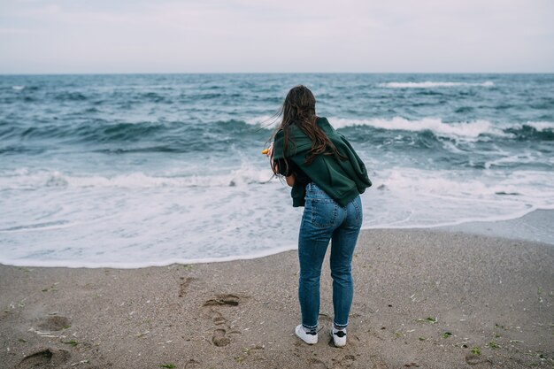 woman shoots on a smartphone the sea waves