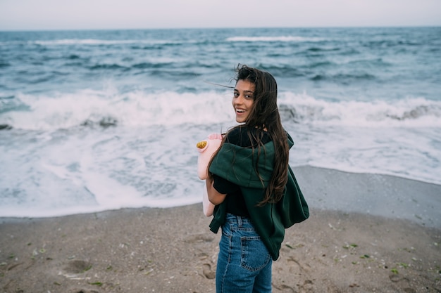 Foto gratuita donna spara su uno smartphone le onde del mare