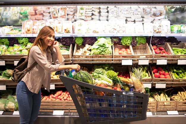 スーパーマーケットの女性とショッピングカート