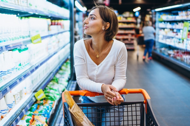 Free photo woman shopping at the grocery store, by the refrigerator