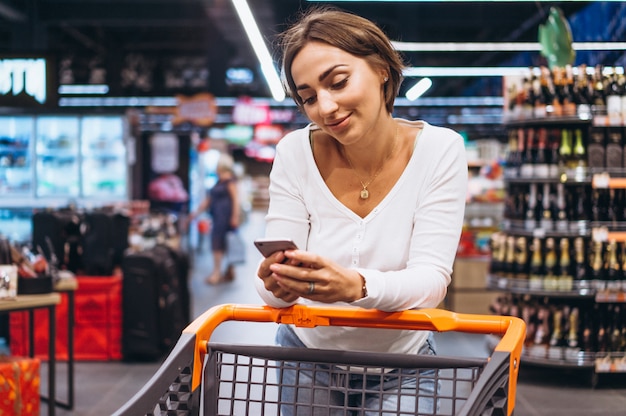 Woman shopping at the grocery store and talking on phone