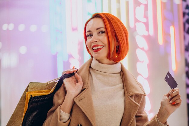 Woman in shopping mall paying with credit card