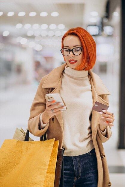 Woman in shopping mall paying with credit card