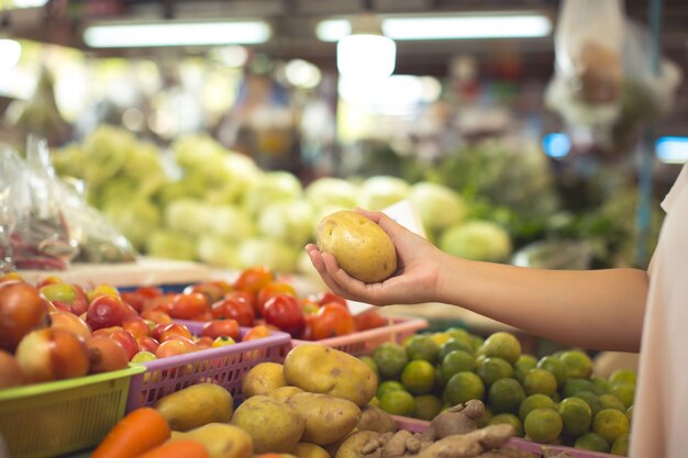 Женщина покупает органические овощи и фрукты