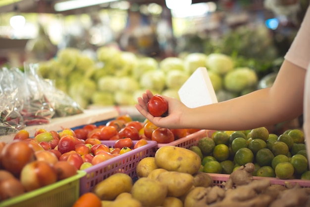 Женщина покупает органические овощи и фрукты