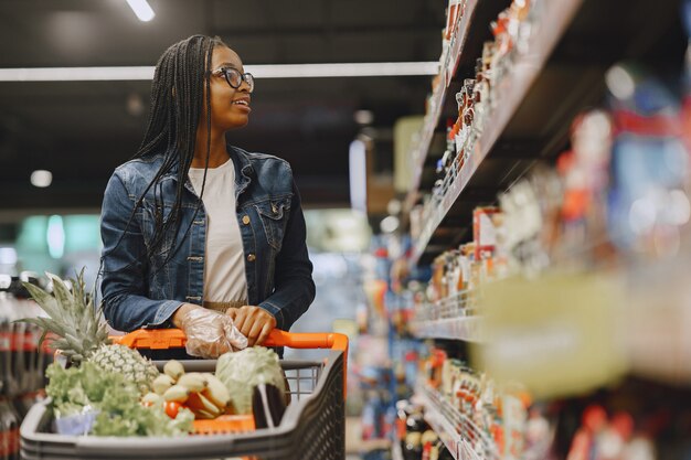Женщина, делающая покупки овощей в супермаркете