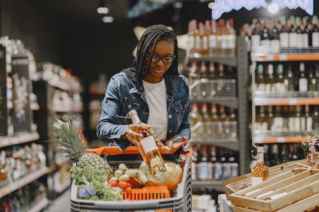 Женщина, делающая покупки овощей в супермаркете