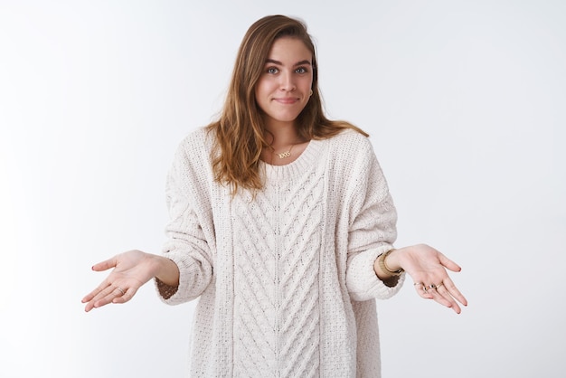 女性の短い髪の緩い居心地の良いセーター肩をすくめる手を横向きに微笑んでぎこちない気づかない