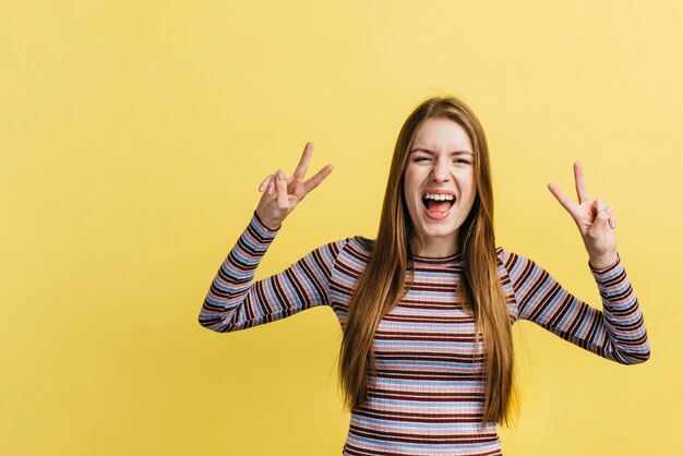 Woman shouting while making the peace sign