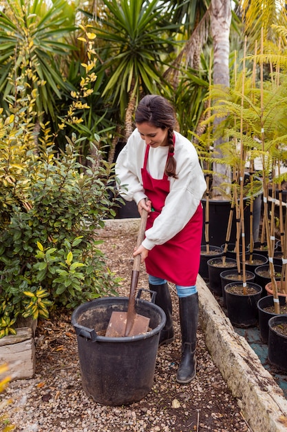 Woman shoveling in large flower pot