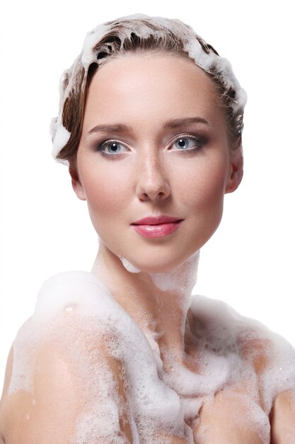 Woman showering with soap on the body and head. Hygiene and skin care concept