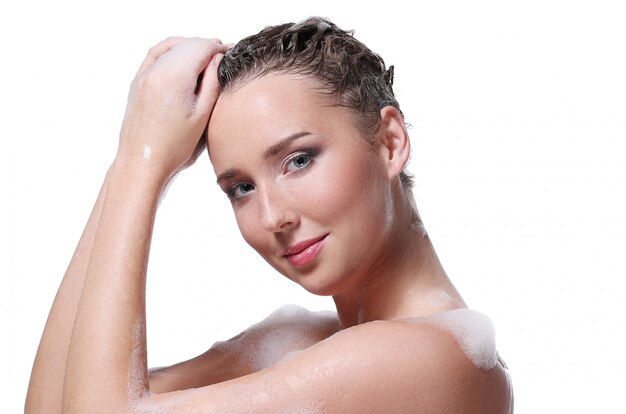 Woman showering with soap on the body and head. Hygiene and skin care concept