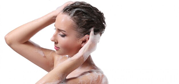 몸과 머리에 비누로 샤워하는 여자. 위생 및 피부 관리 개념