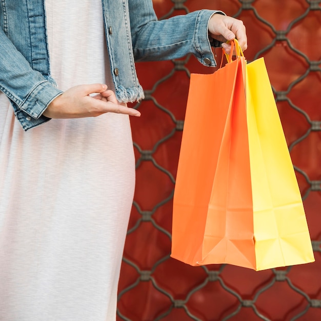 Woman showing on bright shopping packets