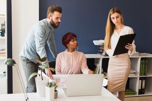 Woman showing clipboard to colleagues