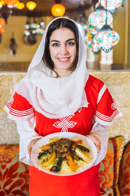 Woman showing dish of arab food