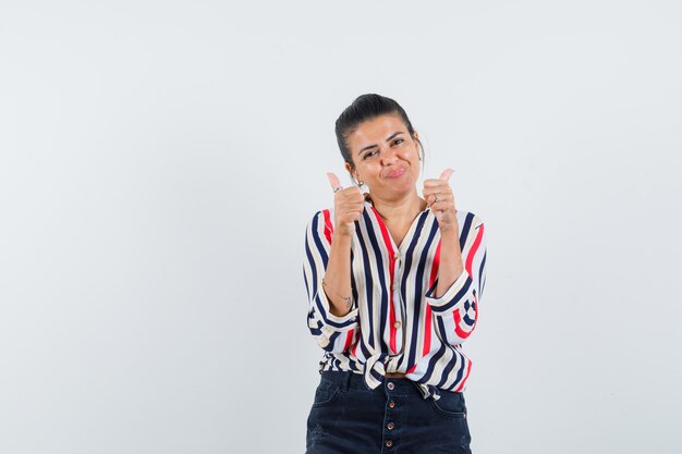 woman showing double thumbs up in shirt, skirt and looking jolly.