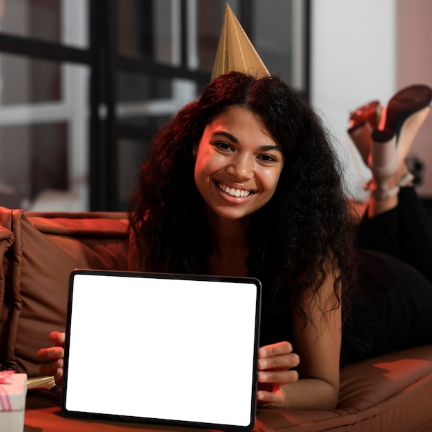 Free photo woman showing an empty screen tablet at a new year's eve party