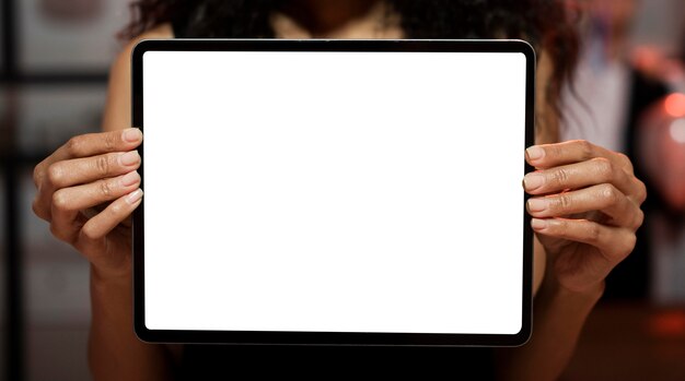 Woman showing an empty screen tablet on new year's eve party