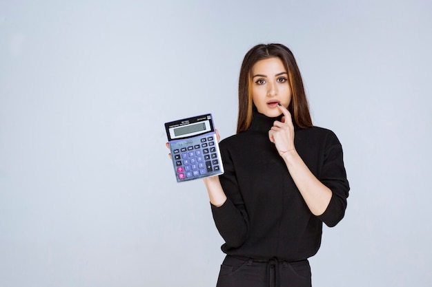 woman showing the final result on the calculator. 