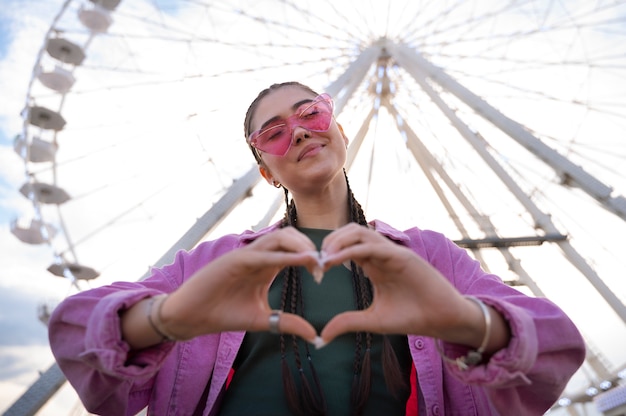 Foto gratuita donna che mostra il segno del cuore con le mani come amicizia