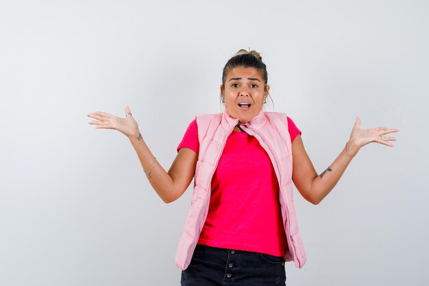 Woman showing helpless gesture in t-shirt, vest and looking agitated