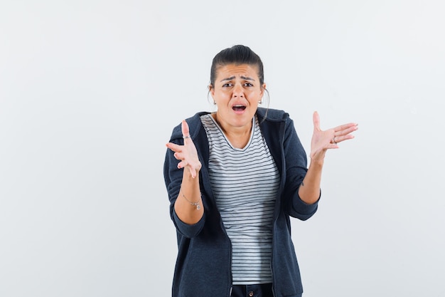 Woman showing helpless gesture in t-shirt