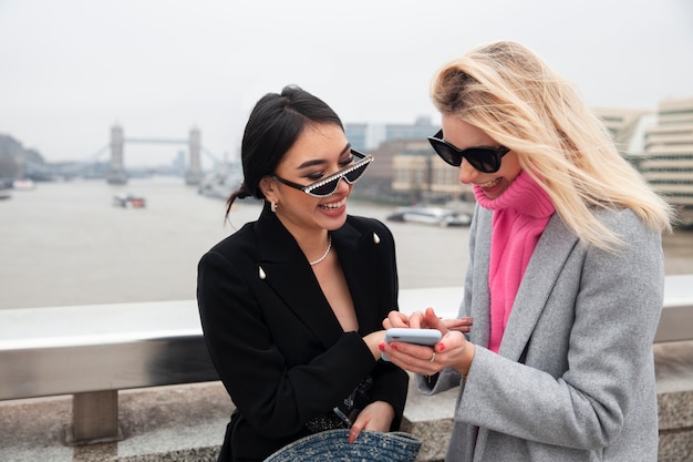 Free photo woman showing her friend something on her smartphone