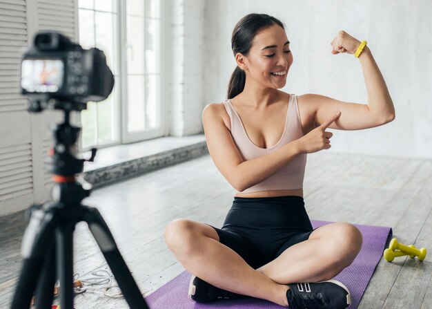 Женщина показывает свои мышцы в видеоблоге