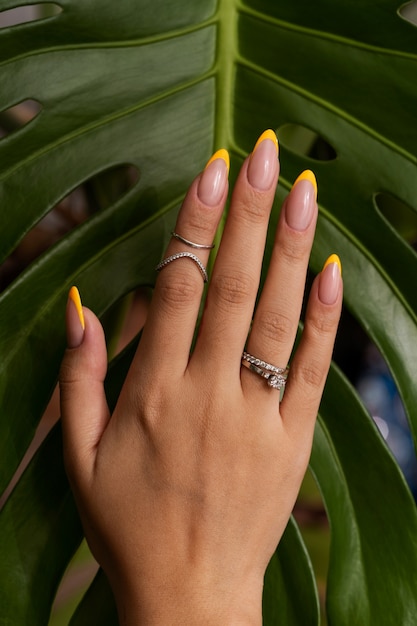 Woman showing her nail art on fingernails against monster leaf