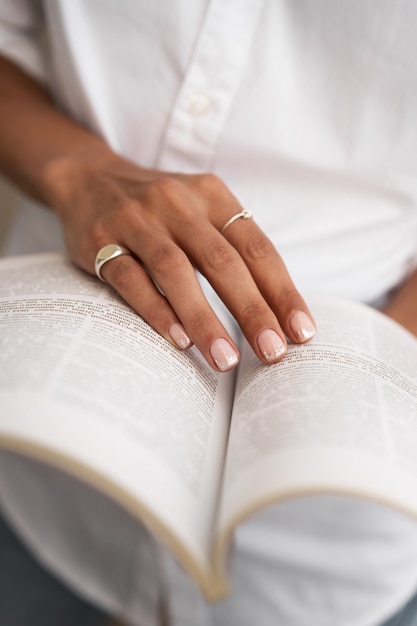 Woman showing her nail art on fingernails with book