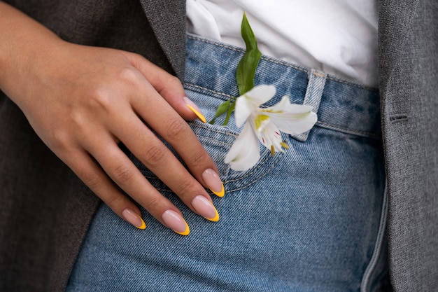 Женщина показывает свой маникюр на ногтях с цветком