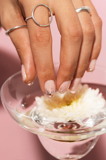 Foto gratuita donna che mostra la sua nail art sulle unghie con vetro