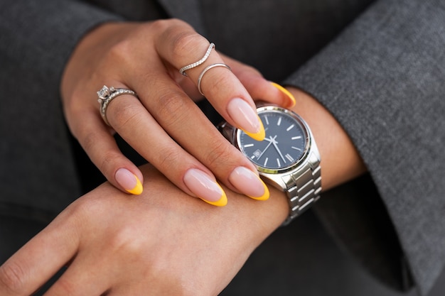 Woman showing her nail art on fingernails with watch