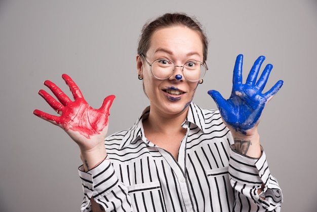 Woman showing her paints hands on gray background