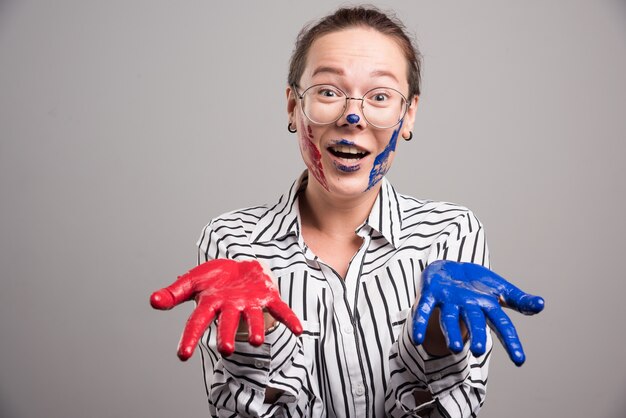 Woman showing her paints hands on gray background