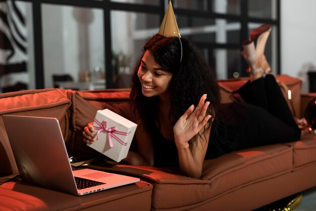 Woman showing her present to some friends while staying on a sofa