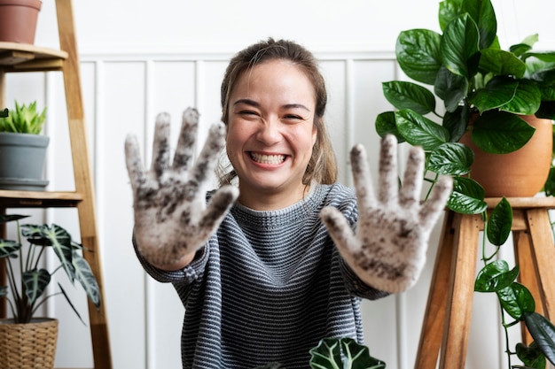 Donna che mostra il suo guanto da giardinaggio sporco