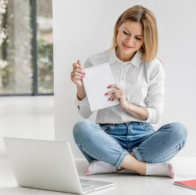 Woman showing her students an empty notepad