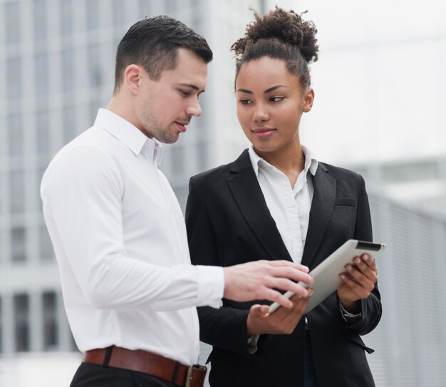 同僚にipadを示す女性