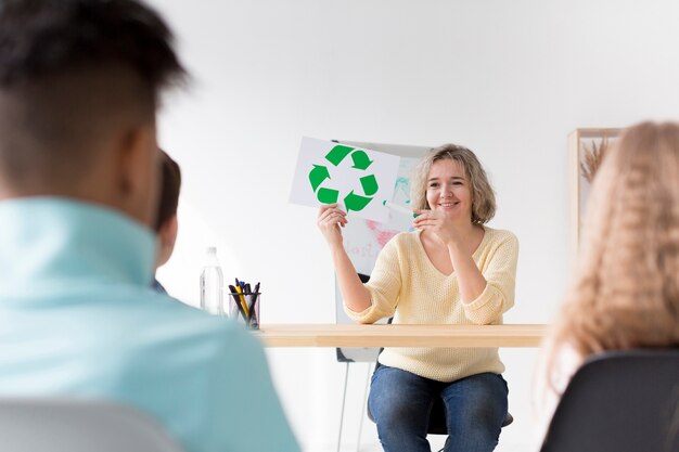 Woman showing kids recycle sign