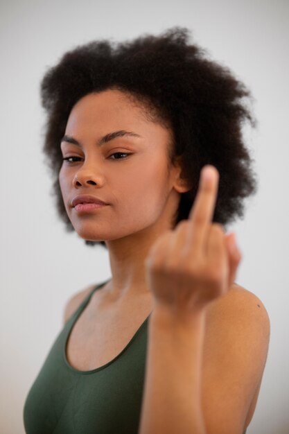 Woman showing middle finger while exercising